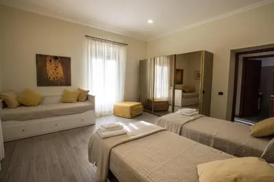 a hotel room with two beds and a couch at Le Cupoline in Rome