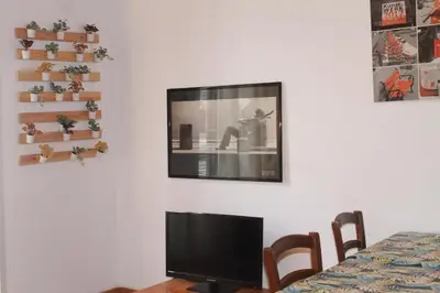 a flat screen tv hanging on a white wall at Daffodil in Roma San Pietro in Rome