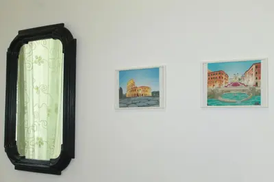 a mirror on a wall with two pictures at Daffodil in Roma San Pietro in Rome