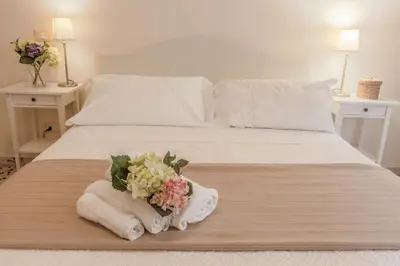 a white bed with a bouquet of flowers on it at Amazing Vaticano in Rome