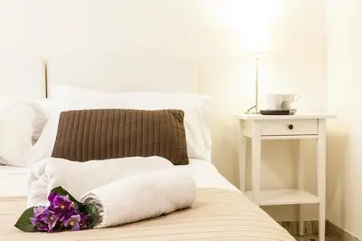 a bed with a pillow and purple flowers on it at Amazing Vaticano in Rome