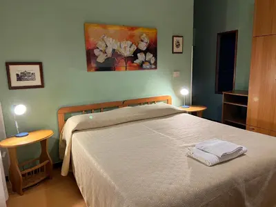 a bedroom with a bed with two tables and a painting at B&B San Michele a Porta Pia in Rome