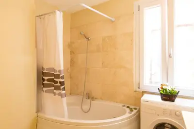 a bathroom with a tub and a washing machine at Savelli Apartment in Rome
