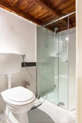 a bathroom with a toilet and a glass shower at Savelli Apartment in Rome