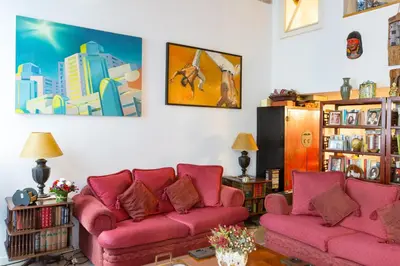 a living room with two pink couches and books at Savelli Apartment in Rome