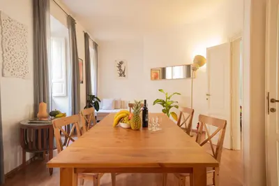 a dining room with a wooden table and chairs at Snooze Trastevere House in Rome
