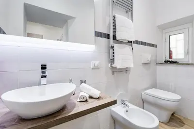a white bathroom with a sink and a toilet at Vatican Prestige Apt by Premium Suites Collection in Rome