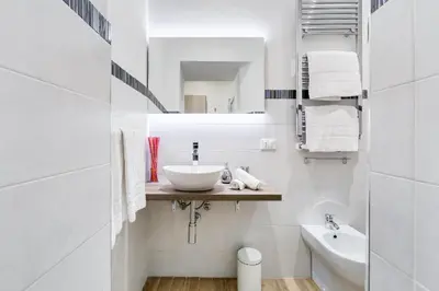 a white bathroom with a sink and a mirror at Vatican Prestige Apt by Premium Suites Collection in Rome