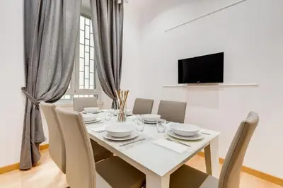 a white dining room with a white table and chairs at Vatican Prestige Apt by Premium Suites Collection in Rome
