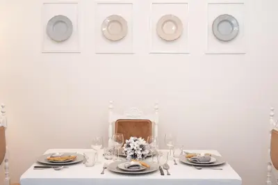 a white table with plates and wine glasses on it at Sweet Arco Farnese in Rome