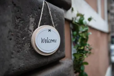 a sign that says welcome hanging on a wall at Sweet Arco Farnese in Rome