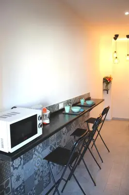 a kitchen with a counter with chairs and a microwave at B&B Pigneto7 in Rome