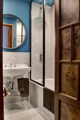 a bathroom with a sink and a tub and a mirror at Luxury Trevi House in Rome