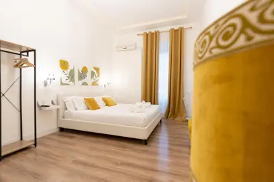 a living room with a white couch and yellow curtains at Vatican Apartment Santamaura in Rome