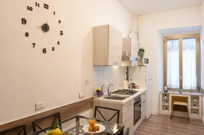 a kitchen with a stove and a clock on the wall at Vatican Apartment Santamaura in Rome