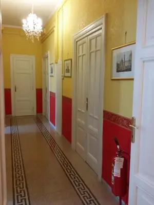 a hallway with red and yellow walls and white doors at La Breccia A Porta Pia in Rome
