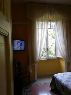a bedroom with a bed and a window with curtains at La Breccia A Porta Pia in Rome
