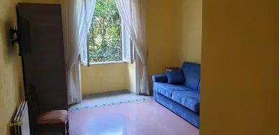 a living room with a blue couch and a window at La Breccia A Porta Pia in Rome