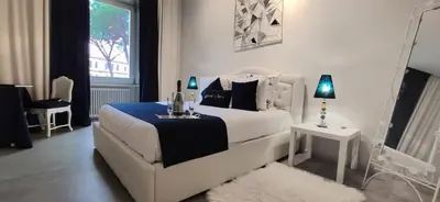 a white bedroom with a white bed and a window at ROMANCE AL COLOSSEO 2 in Rome