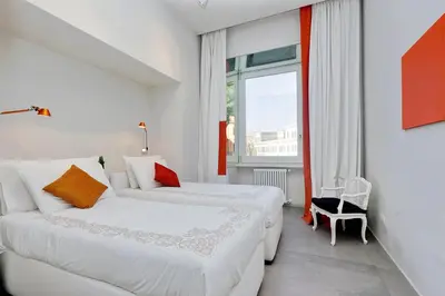 a hotel room with two beds and a window at ROMANCE AL COLOSSEO 2 in Rome