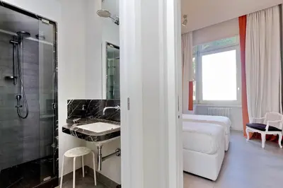 a bathroom with a bed and a sink and a shower at ROMANCE AL COLOSSEO 2 in Rome