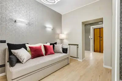a living room with a couch with red and white pillows at Charming Studio - Spanish Steps in Rome