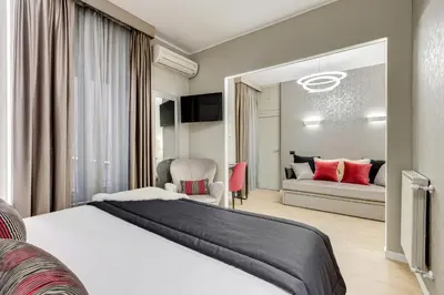 a bedroom with a large white bed and a couch at Charming Studio - Spanish Steps in Rome