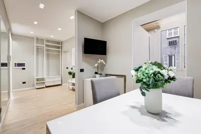a living room with a table with a vase of flowers at Charming Studio - Spanish Steps in Rome