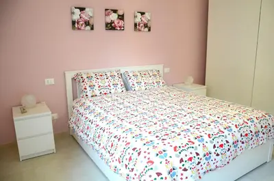 a bedroom with a bed with a white bedspread and pillows at La casa di Egle in Rome