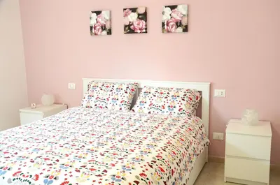 a bedroom with a bed and three pictures on the wall at La casa di Egle in Rome