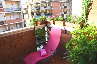 a pink chair sitting on a balcony with plants at La casa di Egle in Rome