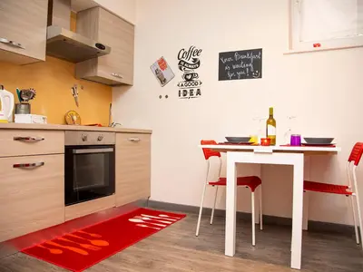 a kitchen with a table and a red rug at San Pietro apart in Rome