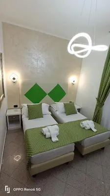 two beds in a room with green and white at House 4 Mori in Rome