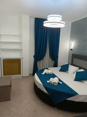 a bedroom with a large bed with blue curtains at House 4 Mori in Rome