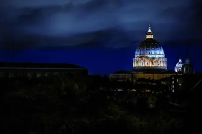 a building with a dome lit up at night at Hotel Il Cantico St. Peter in Rome