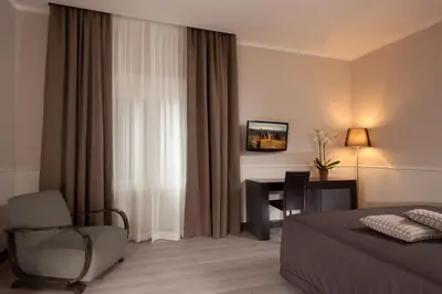 a hotel room with a bed and a chair and a desk at Nazionale 51 Group in Rome