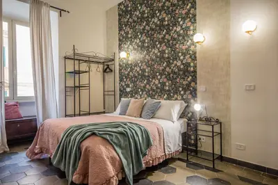 a bedroom with a bed with a floral wallpaper at Appartamento Flora Metro Vittorio in Rome