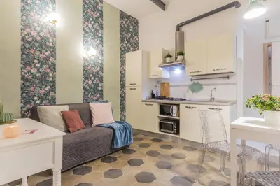 a living room with a couch and a kitchen at Appartamento Flora Metro Vittorio in Rome