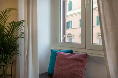 a window with two pillows sitting next to a plant at Appartamento Flora Metro Vittorio in Rome