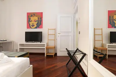 a living room with a bed and a tv at LC GrandTour Libertà in Rome