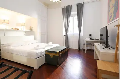 a bedroom with a white bed and a desk at LC GrandTour Libertà in Rome