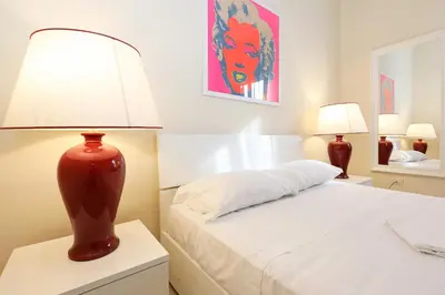 a bedroom with a bed with a red lamp on a night stand at LC GrandTour Libertà in Rome