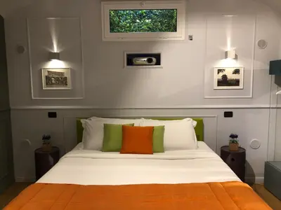 a bedroom with a white bed with colorful pillows at Lata Rana Colosseum Luxury Loft in Rome