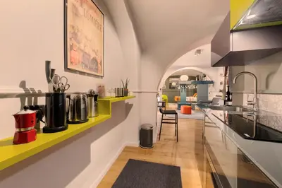 a kitchen with yellow and white walls and a counter at Lata Rana Colosseum Luxury Loft in Rome