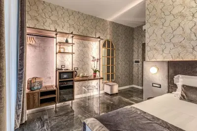 a bedroom with a bed and a desk and a television at Apollo Boutique Hotel in Rome