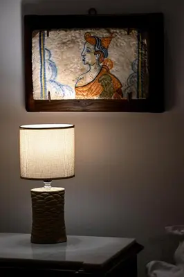 a lamp on a table with a painting on the wall at Vicolo dell'Aquila - Residenze Romanae in Rome