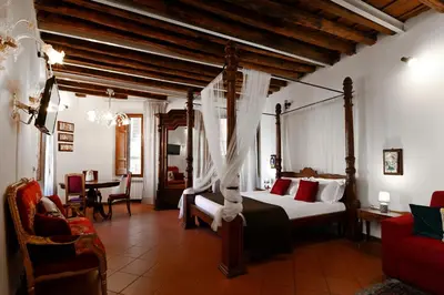 a bedroom with a canopy bed and a dining room at Vicolo dell'Aquila - Residenze Romanae in Rome