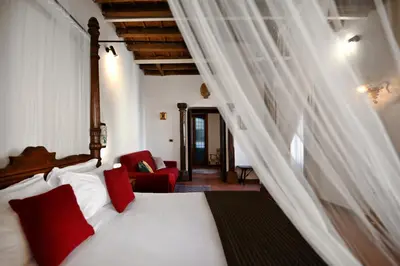 a bedroom with a white bed with red pillows at Vicolo dell'Aquila - Residenze Romanae in Rome