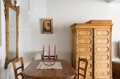 a table with three candles on it next to a dresser at Classic and chic apartments in Trastevere in Rome