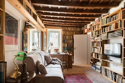 a living room with a couch and bookshelves at Classic and chic apartments in Trastevere in Rome